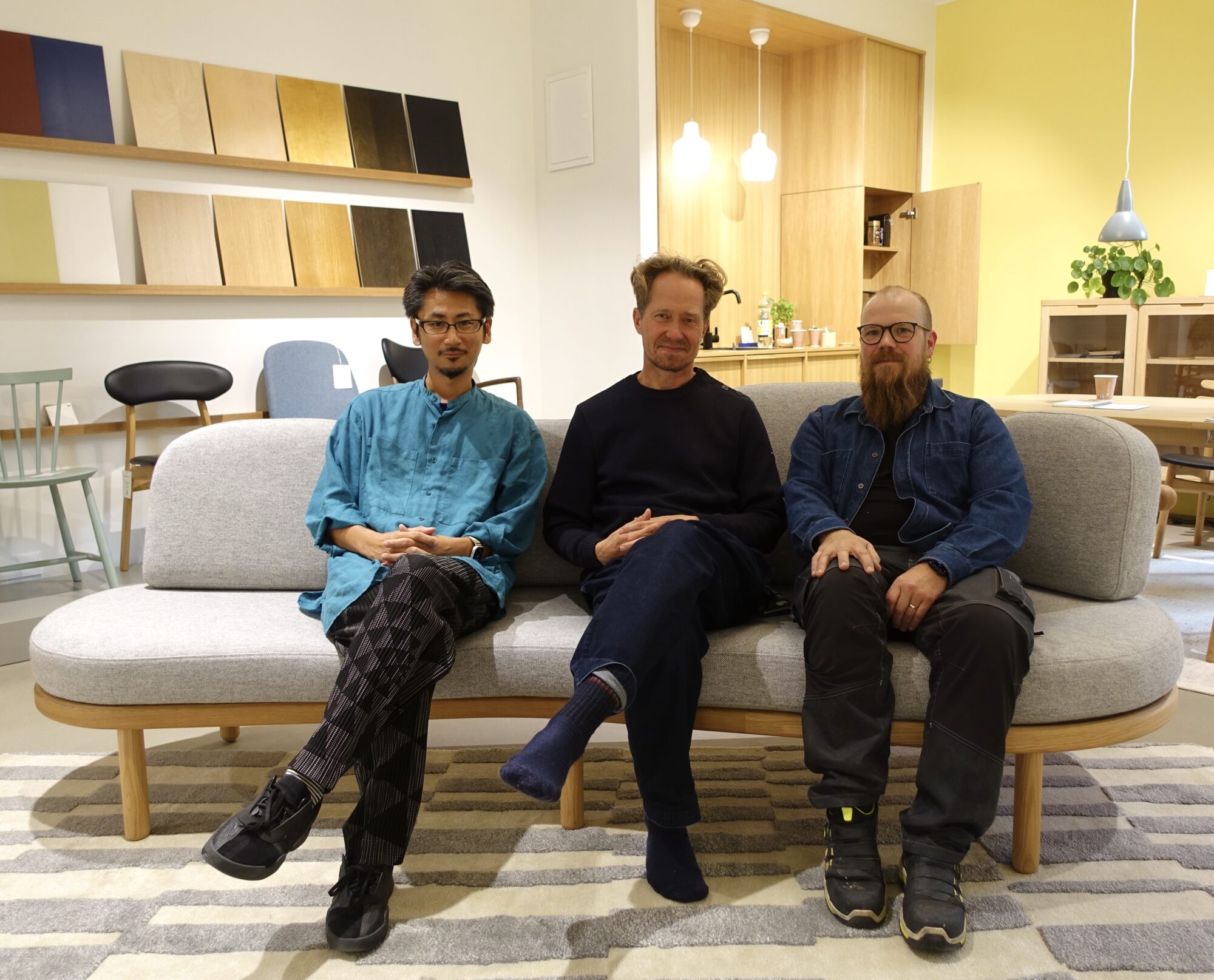 Taishi Watanabe, Esa Vesmanen ja Samuli Ylönen Bulevardin myymälässä Pilvi-sohva prototyypin päällä